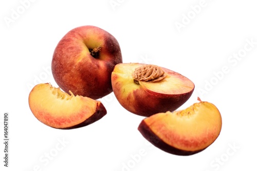 Peaches whole and sliced halves with a bone isolated on white background