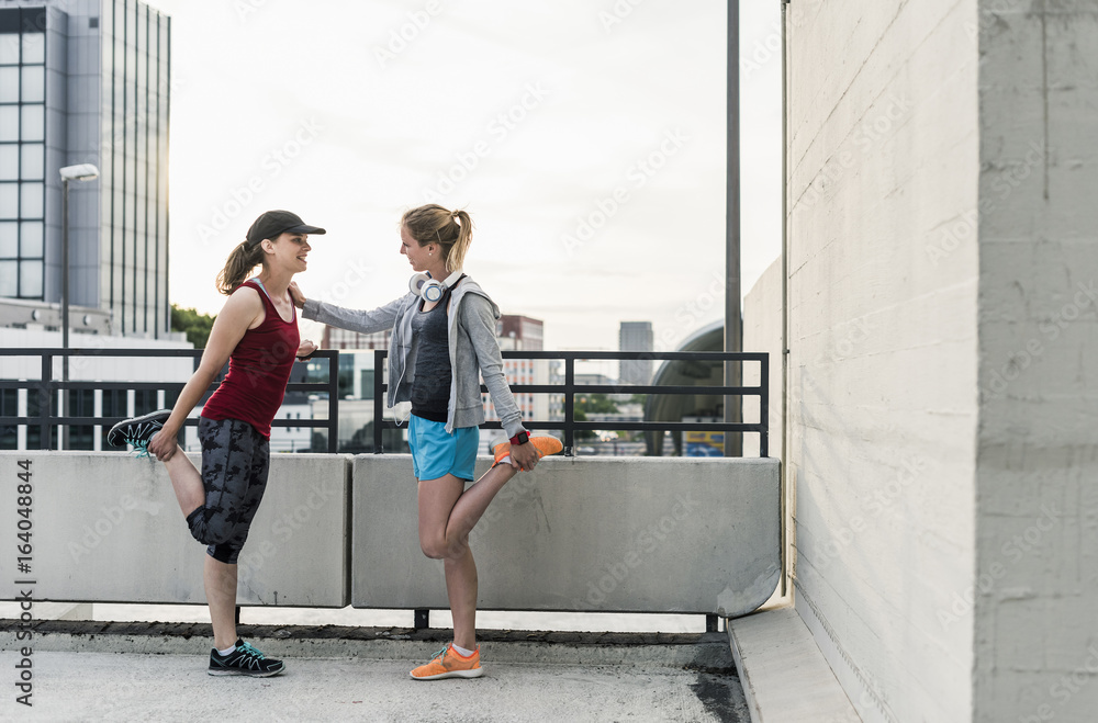 Two active women stretching in the city Two active women stretching in the city