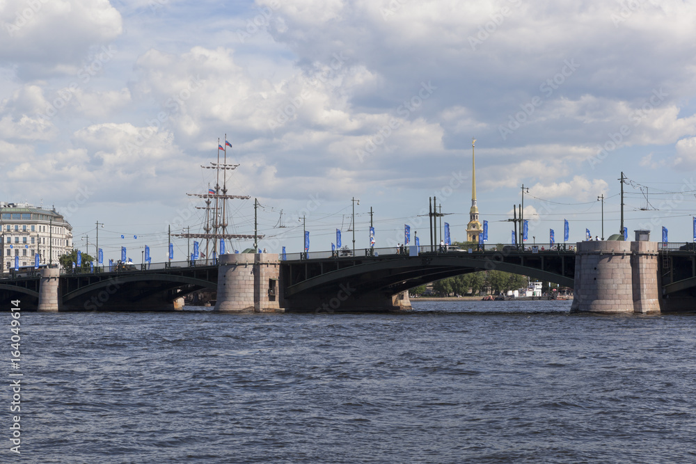 View of the Exchange Bridge from the Makarov Embankment on a Summer Sunny Day in St. Petersburg, Russia View of the Exchange Bridge from the Makarov Embankment on a Summer Sunny Day in St. Petersburg, Russia