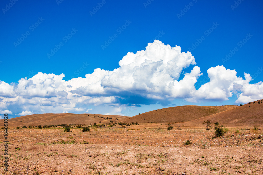 Desert landscape. Blue sky with white clouds. Summer steppe landscape. Hot desert with mountains view. Desert landscape. Blue sky with white clouds. Summer steppe landscape. Hot desert with mountains view.