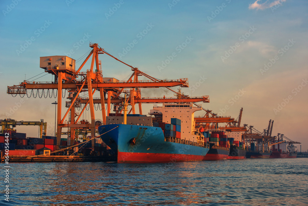 container ship in import export and business logistic.By crane , Trade Port , Shipping.Tugboat assisting cargo to harbor.Aerial view. Top view.