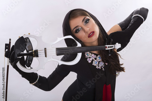 Girl violinist. Beautiful Caucasian girl. Violinist in show costume. On a white background. The violin is white.