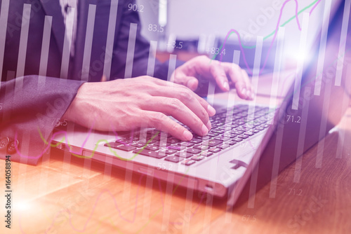 Double exposure stock financial on hand of businessman typing on laptop keyboard. Financial stock market economy analysis. Business people and Economy financial concept.