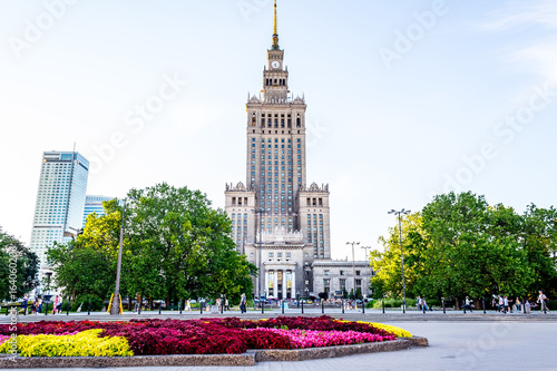 Palace of culture and science in Warsaw on sunny day with blue sky and green trees.  photo