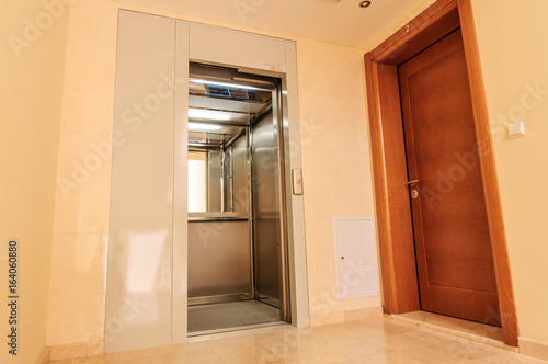 Elevator with new and modern cabin made of bright alloy and metal with modern elevator buttons