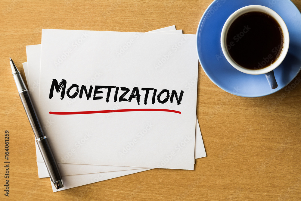 Monetization - handwriting on papers with cup of coffee and pen, business concept Monetization - handwriting on papers with cup of coffee and pen, business concept