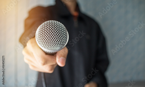blurred of businessman speech talking and reporter with microphone at presentation in conference hall blue background