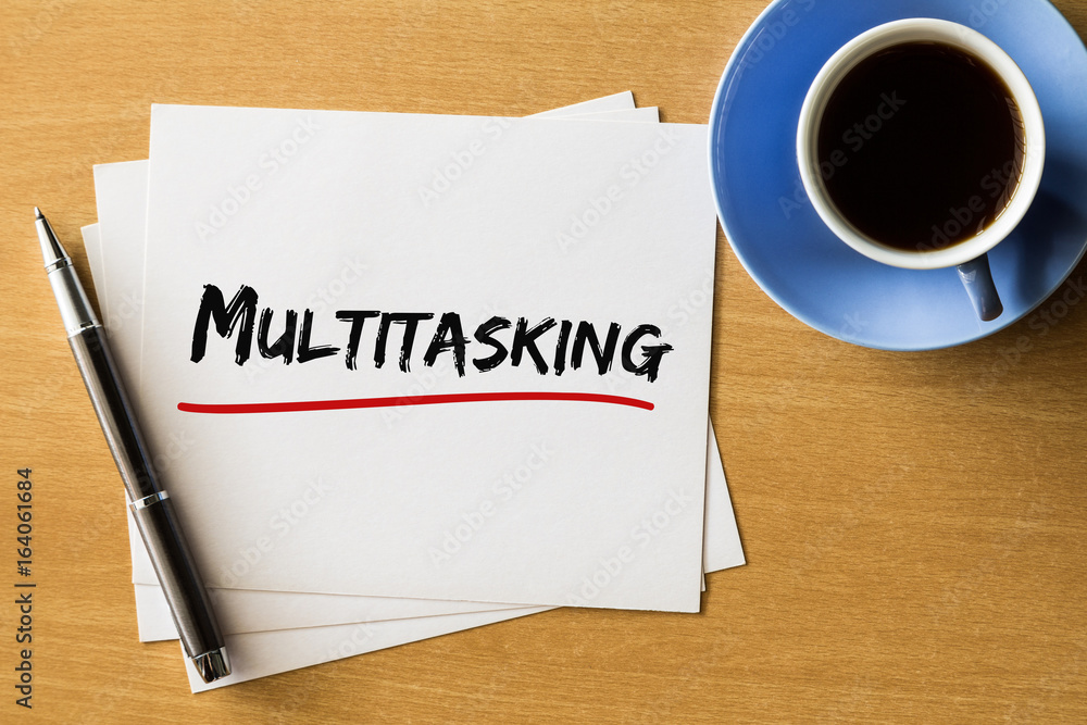 Multitasking - handwriting on papers with cup of coffee and pen, business concept Multitasking - handwriting on papers with cup of coffee and pen, business concept