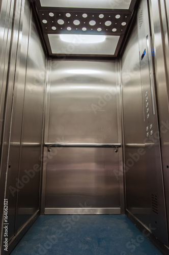 Elevator with new and modern cabin made of bright alloy and metal with modern elevator buttons