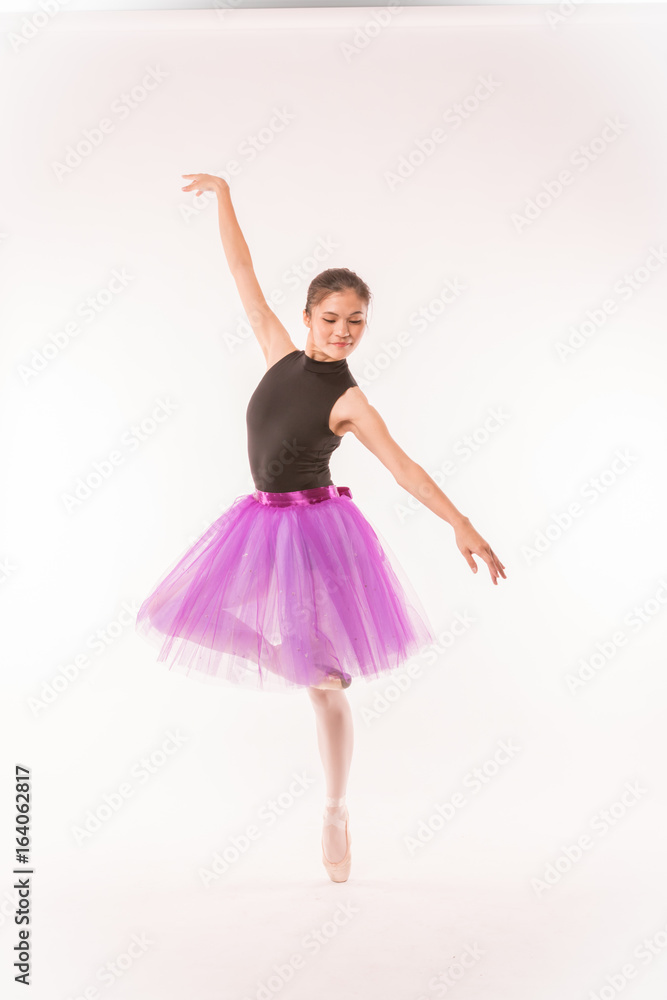 Asian ballerina posing for studio photoshoot with white background