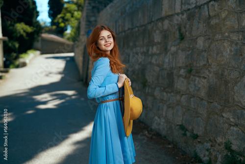 Beautiful young woman in a blue dress walking outdoors in the city © SHOTPRIME STUDIO