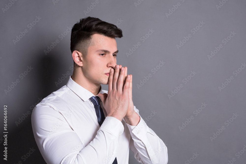 Pensive businessman at gray studio background Pensive businessman at gray studio background