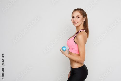 Fitness model woman with dumbbells on white © Prostock-studio