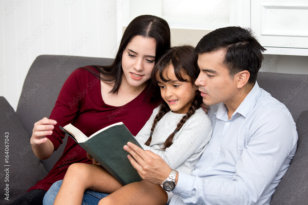 Happy family reading a book with smiling in sofa, happy family concept. Happy family reading a book with smiling in sofa, happy family concept.