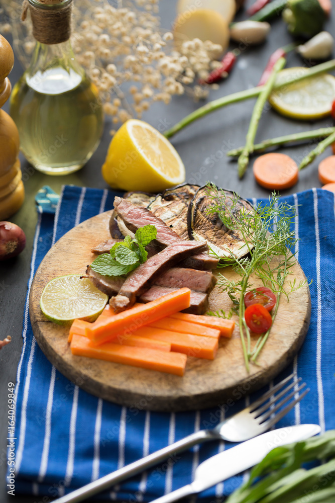 grilled red beef meat sliced with Lemon and carrot on wooden plate grilled red beef meat sliced with Lemon and carrot on wooden plate