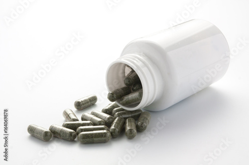 herb capsule from bottle isolated