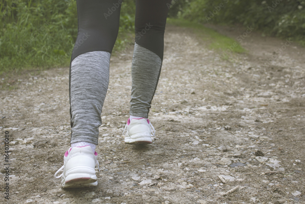 Woman running legs in sunset forest