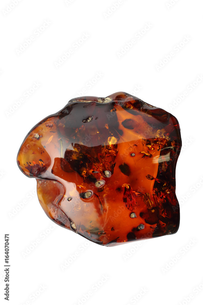 Amber. Natural polished piece of red Baltic amber on a white background. A beautiful mineral. Petrified resin of ancient trees. A sunny stone. Transparent amber with inclusions.