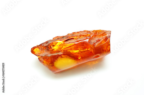 Amber. Natural polished piece of Baltic amber elongated shape on a white background. A beautiful mineral. Petrified resin of ancient trees. A sunstone. Amber crust.