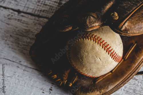 old Baseball and glove on wood background with filter effect retro vintage style