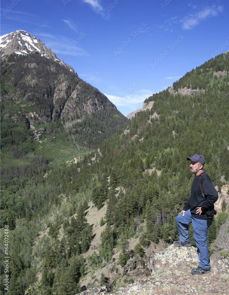 A Photographer Stands on a Mountain Overlook