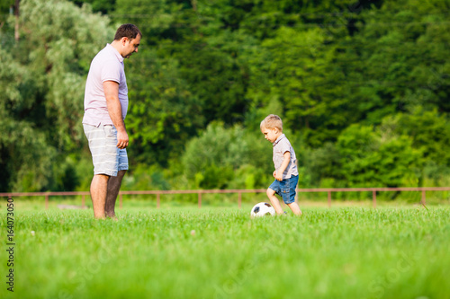 Father and son playing football © oksix