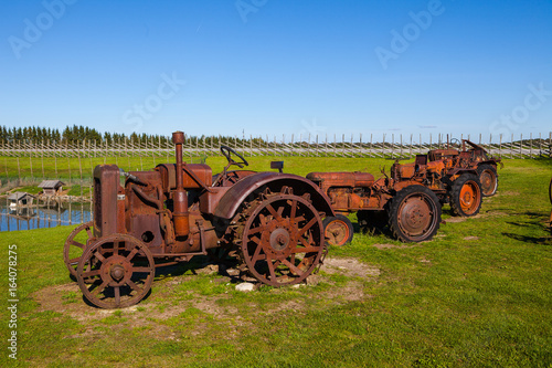 Rusty vintage tractors in the field. Museum installation.