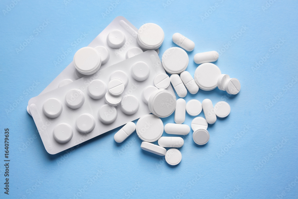 White pills on color background