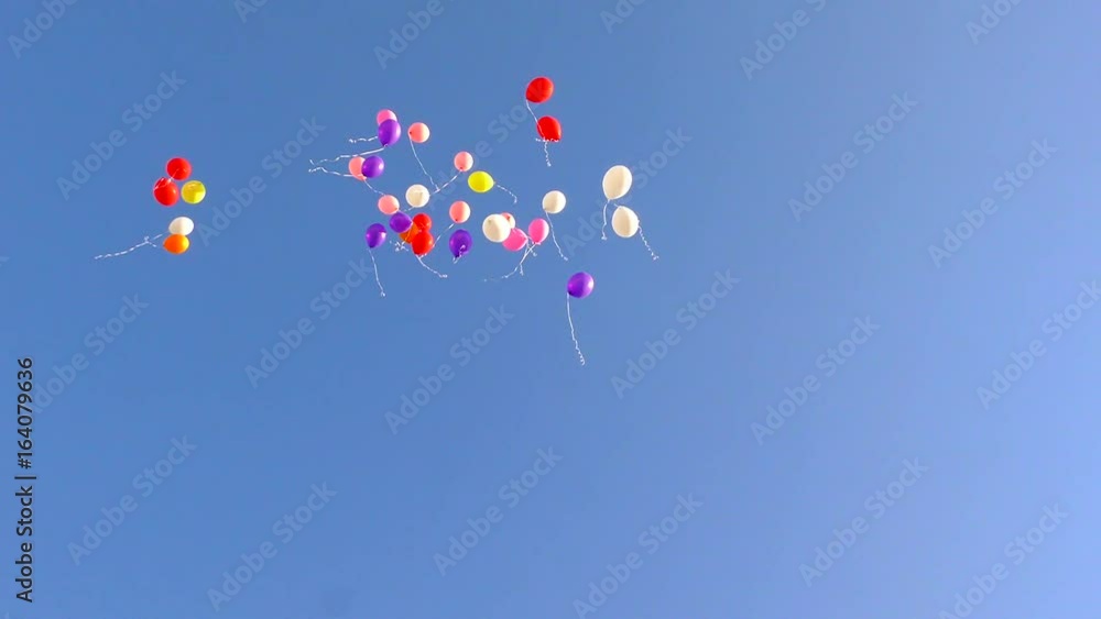 Multicolored balloons flying up in blue sky. Festive launch of gel balls in flight. Multicolored balloons flying up in blue sky. Festive launch of gel balls in flight.