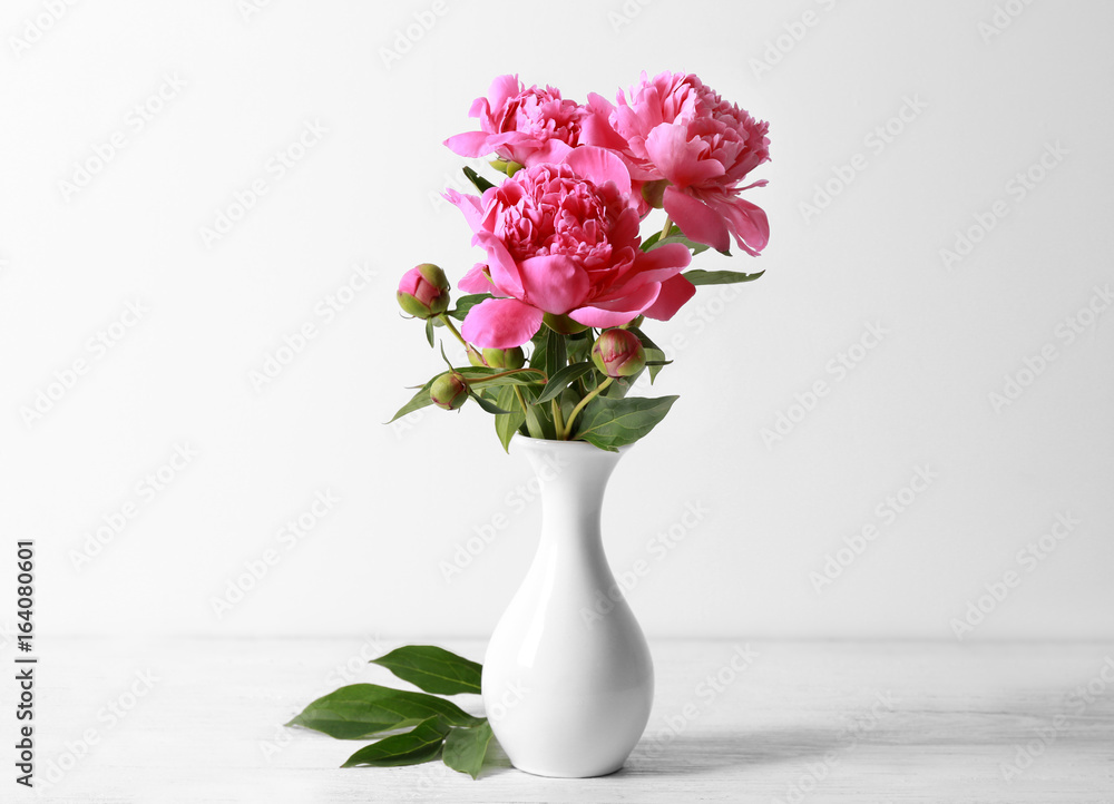 Vase with beautiful peonies on white background