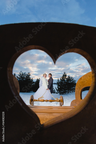 Bride and groom in the heart-shaped frame