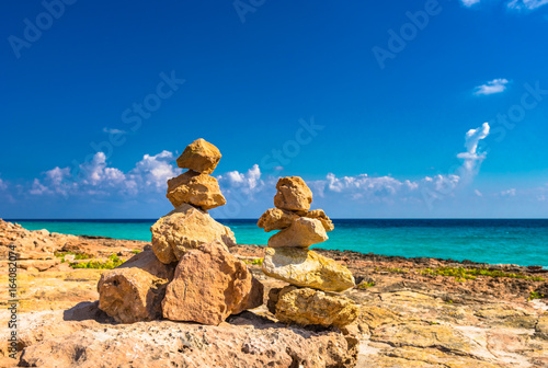 Relaxing on the beach, balanced stone stacks