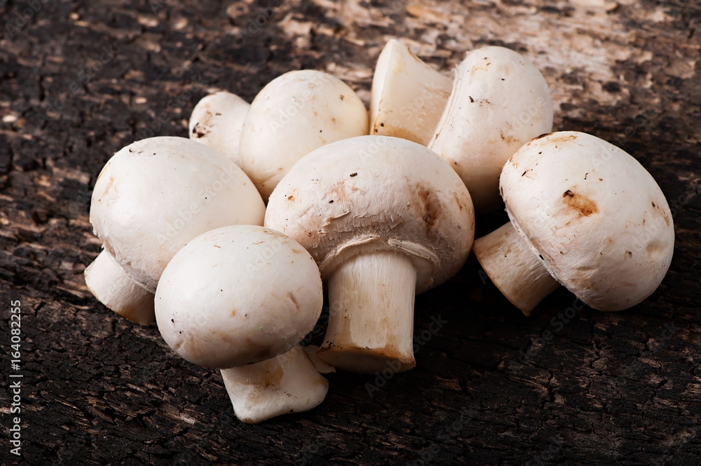Mushrooms champignons on an old wooden background. Mushrooms champignons on an old wooden background.