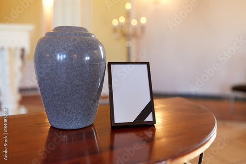 photo frame with mourning ribbon and cremation urn photo