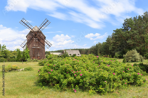 Zabytkowy wiatrak drewniany typu koźlak, w przeszłości charakterystyczny dla polskiego krajobrazu wiejskiego.
