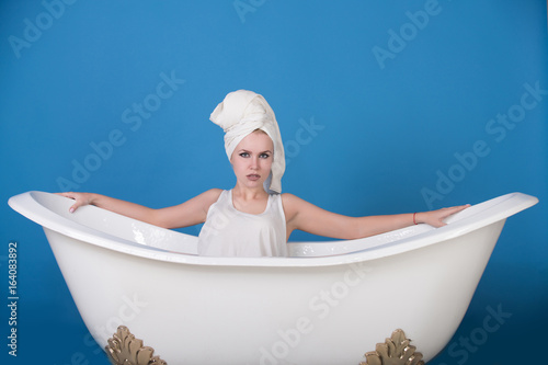 girl with towel turban sitting in white bathtub © Volodymyr