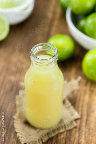 Fresh Lime Juice on wooden background (selective focus)
