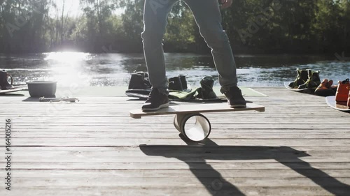 Men on Deck for balance board. Rocker-roller boards. Wooden deck for balanceboard. solid plastic roller for balance board. Rocker-roller boards. Surfing wakeboard training photo