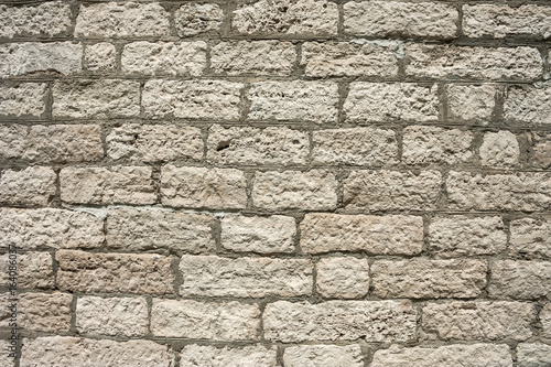 The masonry of an ancient stone wall eroded. Close-up