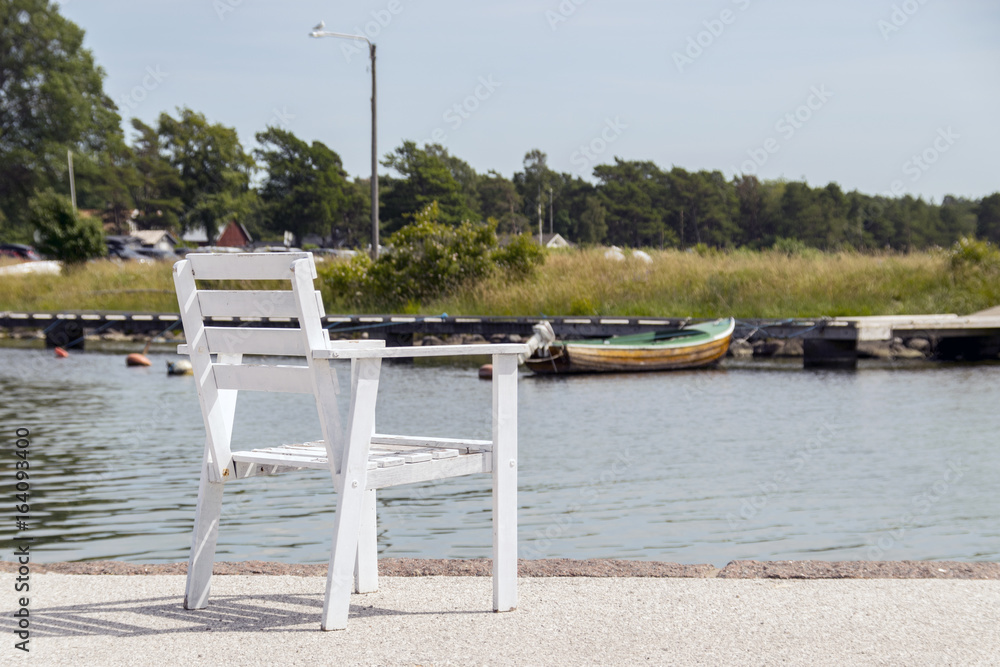 Fototapeta premium En tom vit stol på kajen
