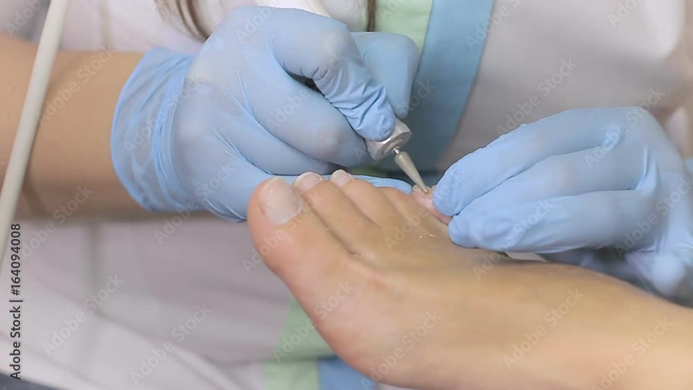 The beautician makes a pedicure to woman The beautician makes a pedicure to woman