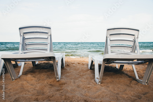 Two loungers on a sandy beach