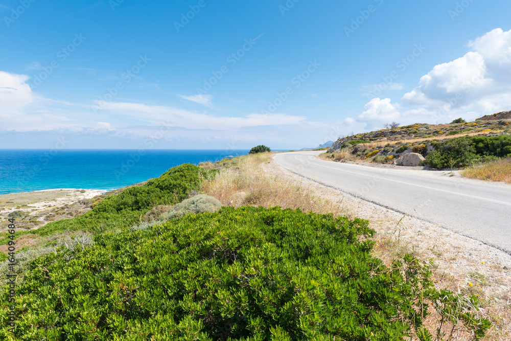 Beautiful coastal road along crystal blue sea water on Milos island. Cyclades, Greece