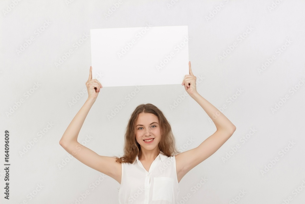 Young woman holding blank poster.Smiling woman sign board holding. Girl showing banner with copy space. Young woman holding blank poster.Smiling woman sign board holding. Girl showing banner with copy space.
