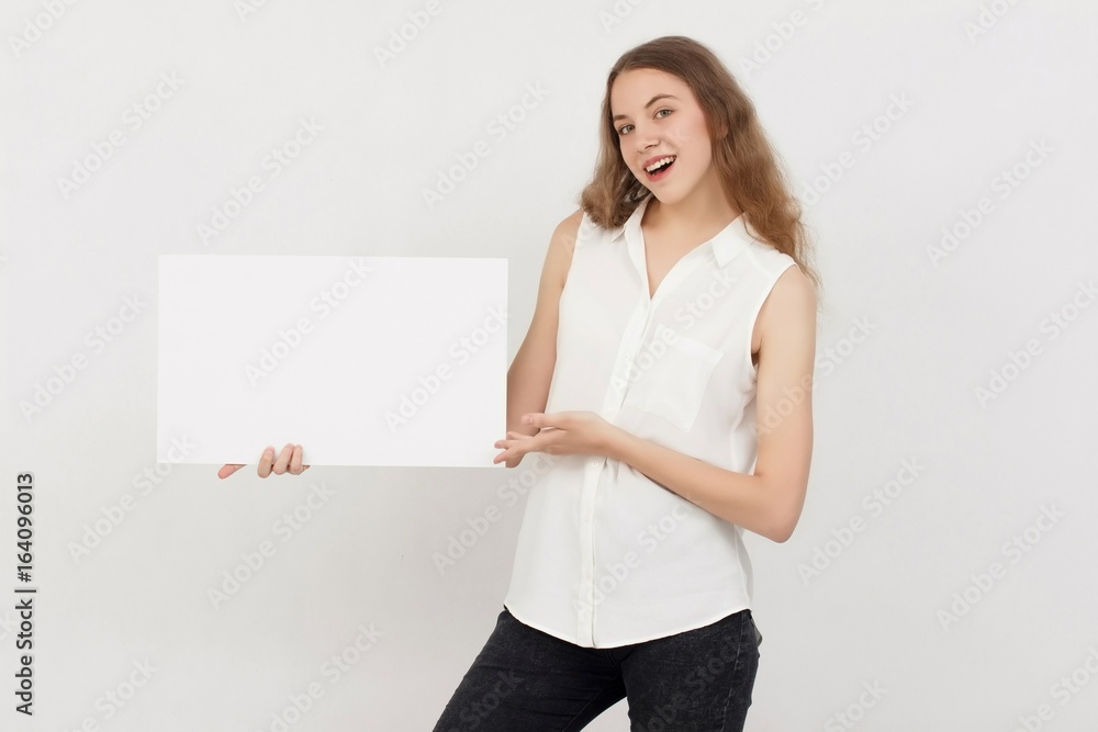 Young woman holding blank poster.Smiling woman sign board holding. Girl showing banner with copy space. Young woman holding blank poster.Smiling woman sign board holding. Girl showing banner with copy space.