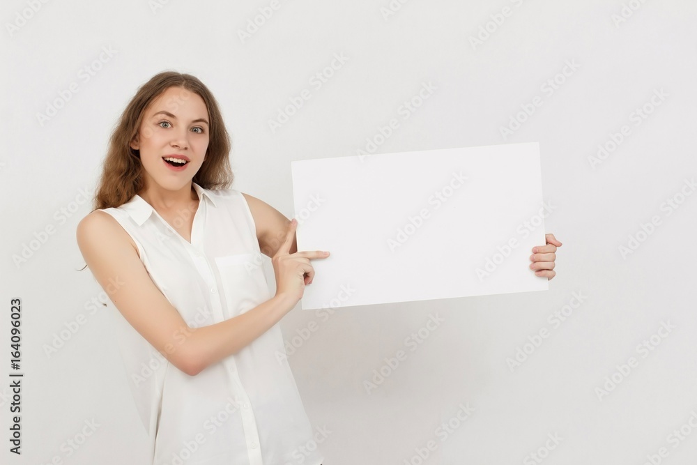 Young woman holding blank poster.Smiling woman sign board holding. Girl showing banner with copy space. Young woman holding blank poster.Smiling woman sign board holding. Girl showing banner with copy space.