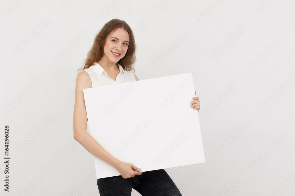 Young woman holding blank poster.Smiling woman sign board holding. Girl showing banner with copy space. Young woman holding blank poster.Smiling woman sign board holding. Girl showing banner with copy space.