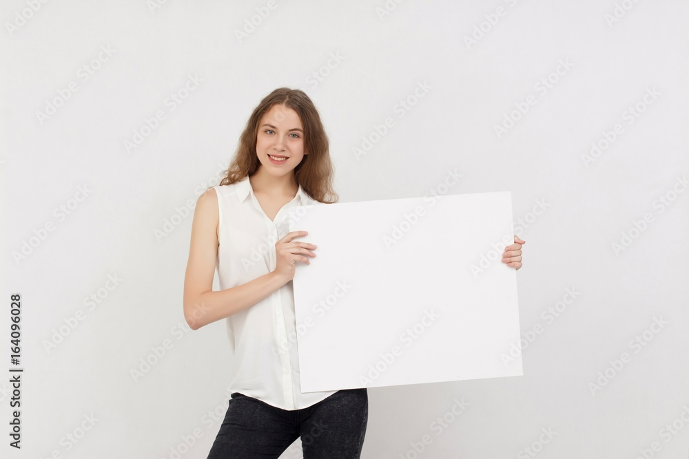Young woman holding blank poster.Smiling woman sign board holding. Girl showing banner with copy space. Young woman holding blank poster.Smiling woman sign board holding. Girl showing banner with copy space.