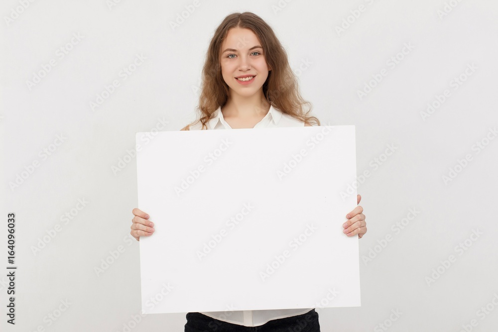 Young woman holding blank poster.Smiling woman sign board holding. Girl showing banner with copy space. Young woman holding blank poster.Smiling woman sign board holding. Girl showing banner with copy space.