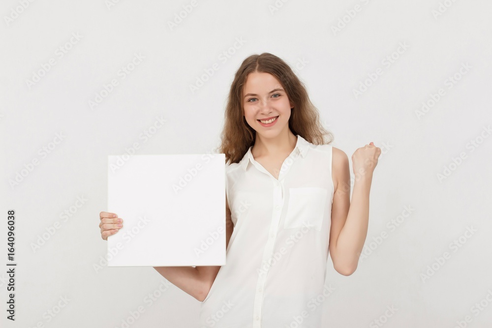 Young woman holding blank poster.Smiling woman sign board holding. Girl showing banner with copy space. Young woman holding blank poster.Smiling woman sign board holding. Girl showing banner with copy space.